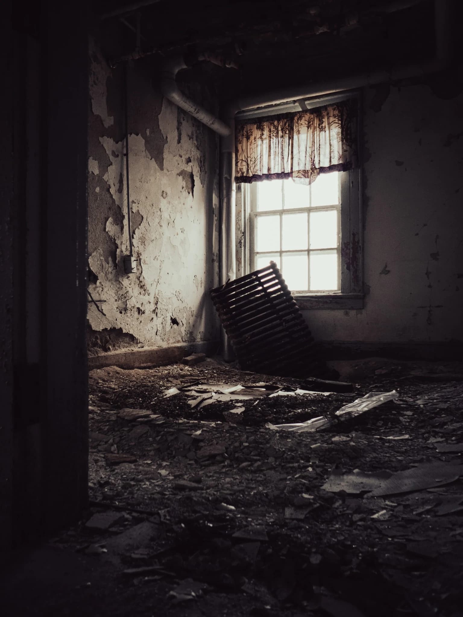 Abandoned room with peeling walls and a bright window