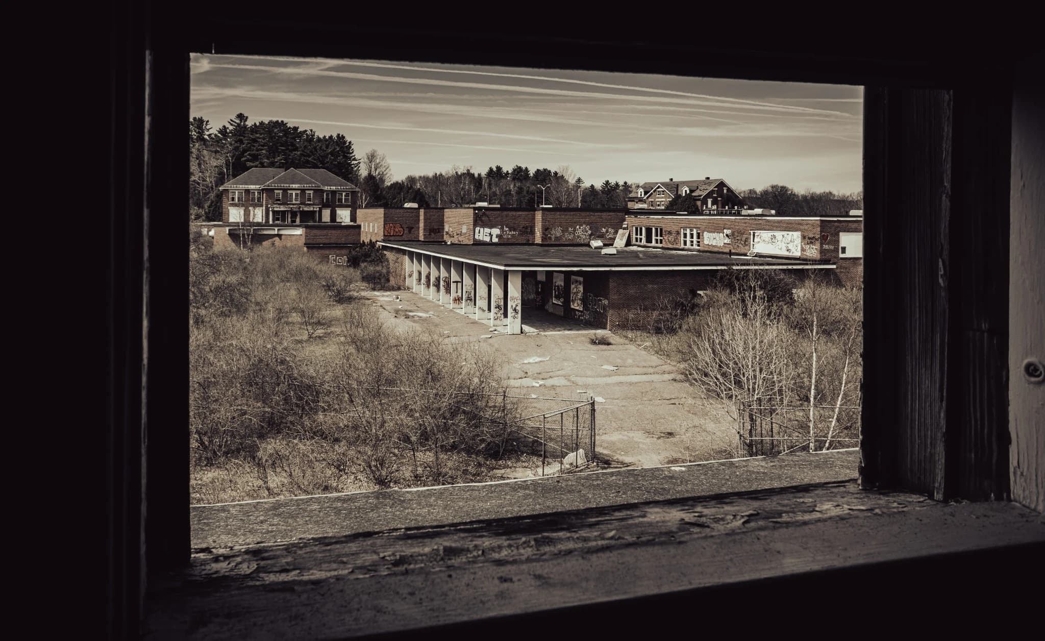 Abandoned buildings viewed through an old window